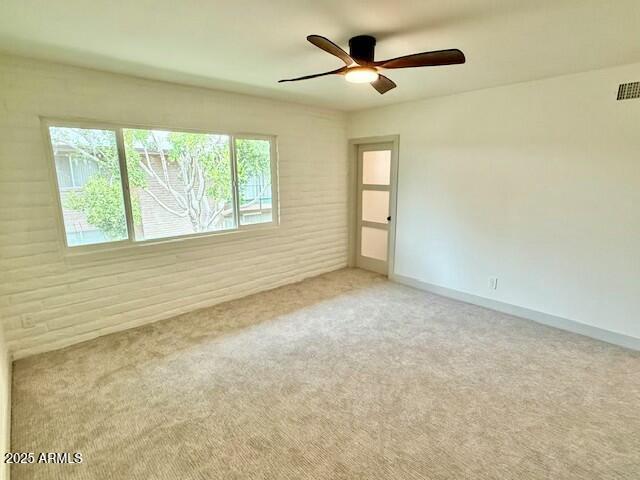 spare room with carpet flooring, baseboards, and ceiling fan