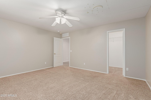 22905 N 19th Way, Phoenix, AZ 85024 - unfurnished bedroom with a walk in closet, light colored carpet, baseboards, a closet, and a ceiling fan