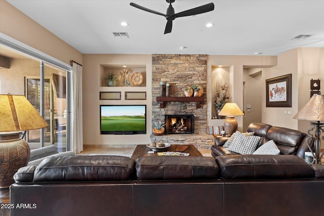 living room with ceiling fan, built in shelves, and a fireplace