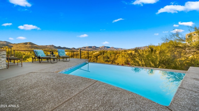 view of pool featuring a patio area and a mountain view