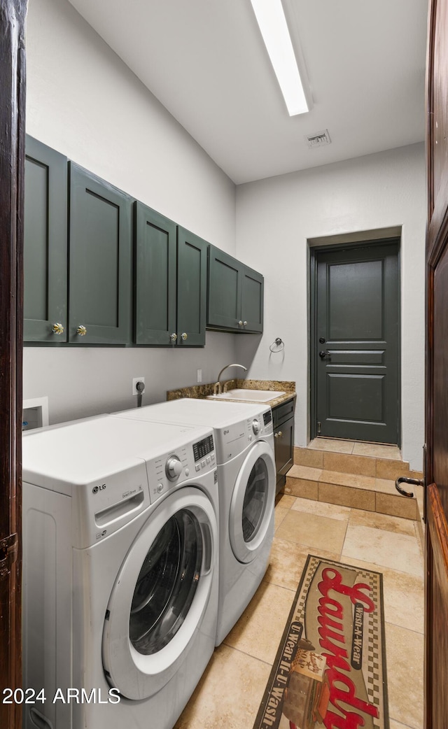 laundry area featuring cabinets, light tile patterned floors, washer and dryer, and sink