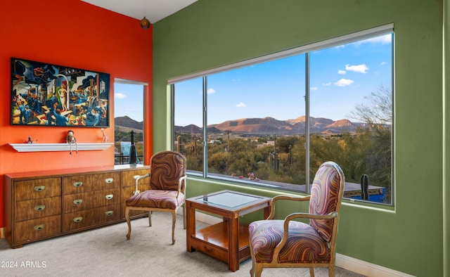 living area with a mountain view and light carpet