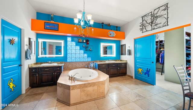 bathroom featuring tile patterned floors, tiled tub, vanity, and an inviting chandelier