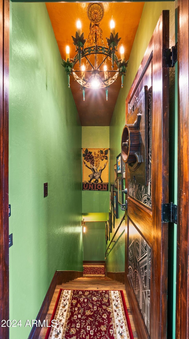 hallway with a chandelier and wood-type flooring