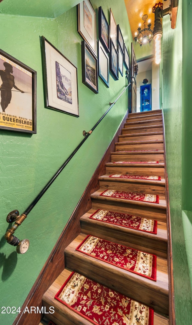 stairs featuring a chandelier