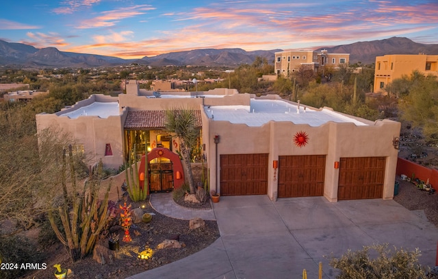 adobe home with a mountain view and a garage