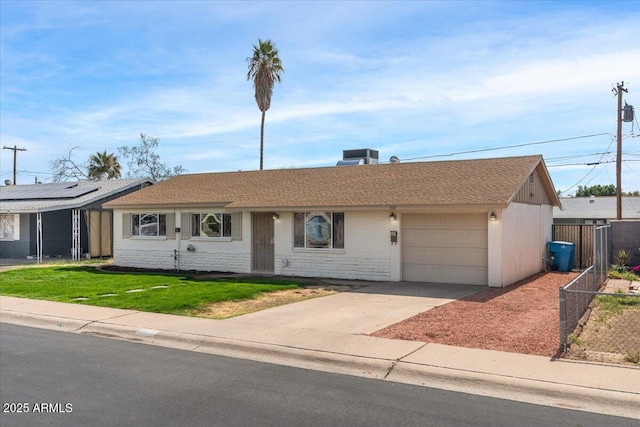 ranch-style home with central air condition unit, a garage, fence, concrete driveway, and a front lawn