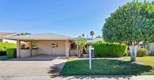 view of front of home with a front lawn and a carport