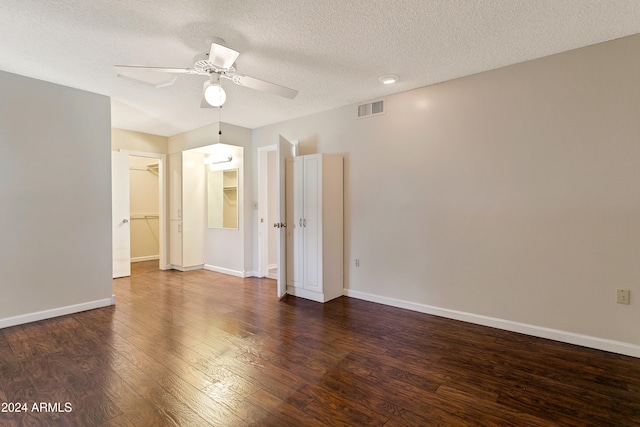 unfurnished room featuring a textured ceiling, ceiling fan, and dark hardwood / wood-style flooring