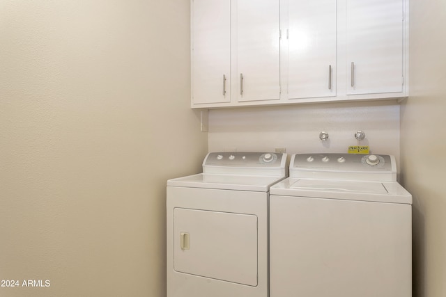 laundry room featuring washer and dryer and cabinets