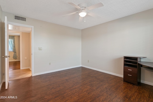 unfurnished room featuring ceiling fan, a textured ceiling, and dark hardwood / wood-style flooring