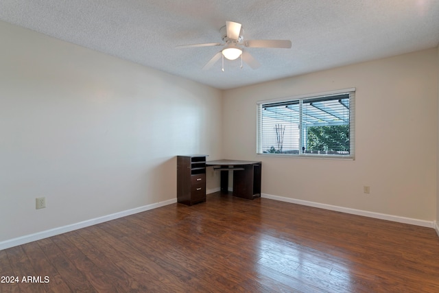 empty room with ceiling fan, dark wood-type flooring, and a textured ceiling