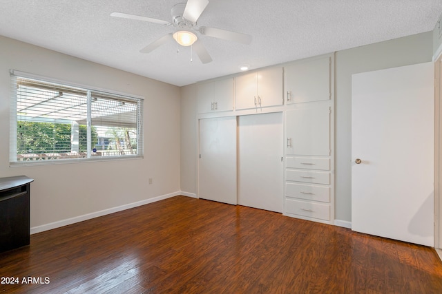 unfurnished bedroom featuring a textured ceiling, ceiling fan, a closet, and dark hardwood / wood-style floors