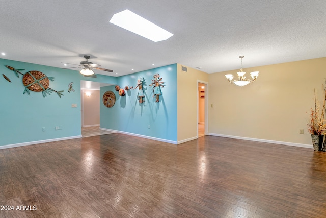 unfurnished room featuring a textured ceiling, dark hardwood / wood-style flooring, and ceiling fan with notable chandelier