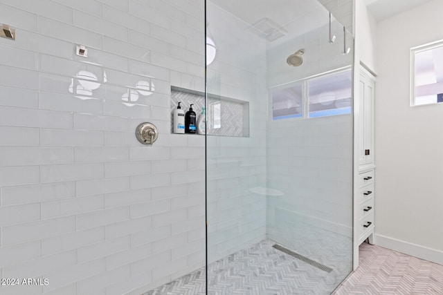 bathroom with tile flooring and a shower with shower door