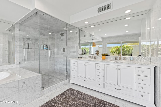 bathroom with tile flooring, shower with separate bathtub, and double vanity