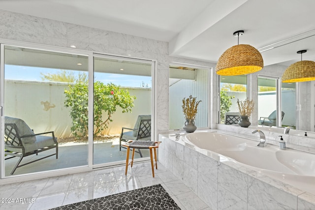 bathroom featuring a relaxing tiled bath, tile flooring, and a wealth of natural light