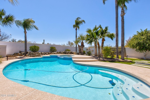 view of swimming pool with an in ground hot tub