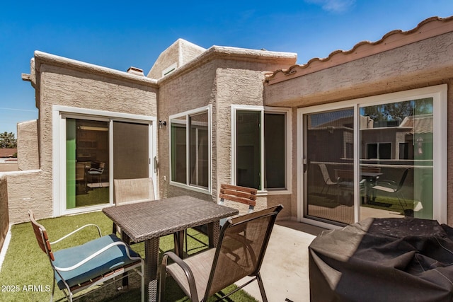rear view of house featuring stucco siding