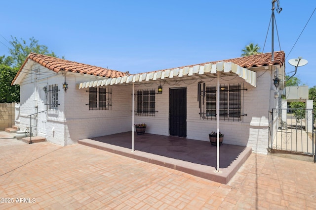 541 W Vernon Ave, Phoenix, AZ 85003 - mediterranean / spanish-style home featuring a tiled roof, a patio, and brick siding