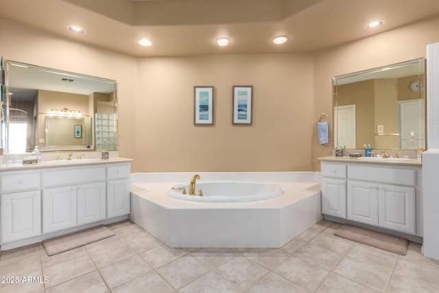 bathroom featuring vanity, tile patterned floors, and tiled tub