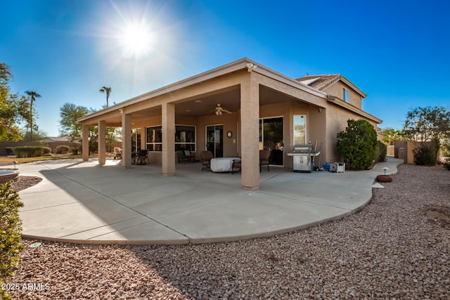 back of house with ceiling fan and a patio