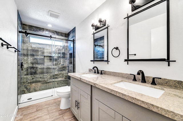 bathroom featuring vanity, toilet, walk in shower, and a textured ceiling