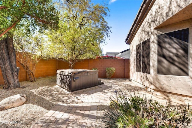 view of patio featuring a fenced backyard and a hot tub