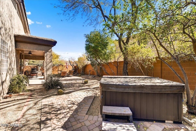 view of patio with fence private yard and a hot tub