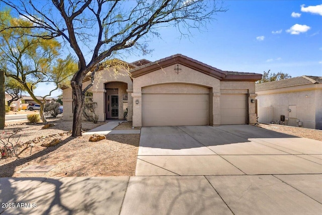 mediterranean / spanish-style house with concrete driveway, an attached garage, a tile roof, and stucco siding