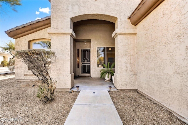 entrance to property featuring stucco siding