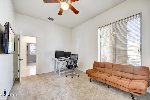 office space featuring carpet, visible vents, and a ceiling fan