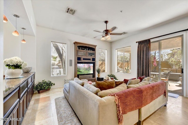 living area with visible vents, ceiling fan, and light tile patterned floors