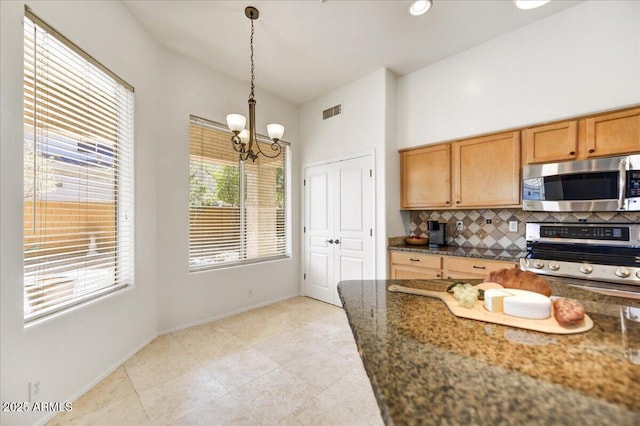 kitchen with visible vents, appliances with stainless steel finishes, tasteful backsplash, dark stone countertops, and pendant lighting