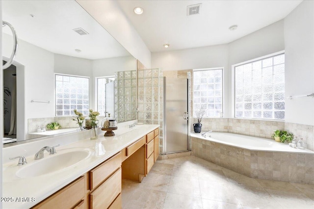 bathroom with a garden tub, a shower stall, visible vents, and a sink