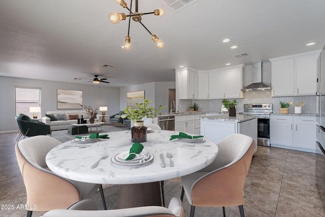 tiled dining area featuring ceiling fan and sink