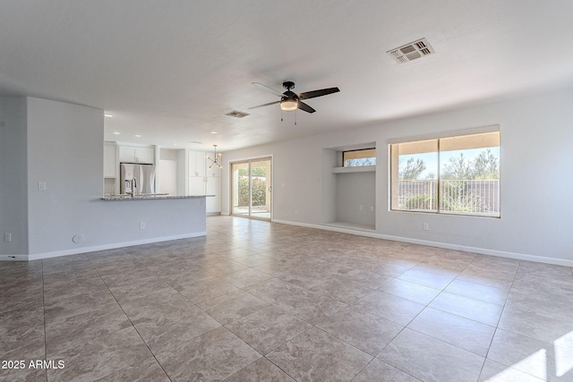 unfurnished living room featuring light tile patterned floors and ceiling fan with notable chandelier