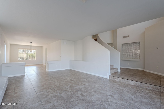 unfurnished room featuring a notable chandelier