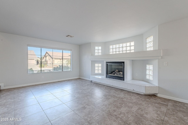 unfurnished living room with light tile patterned floors and a wealth of natural light