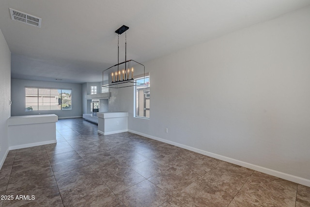 unfurnished dining area featuring an inviting chandelier