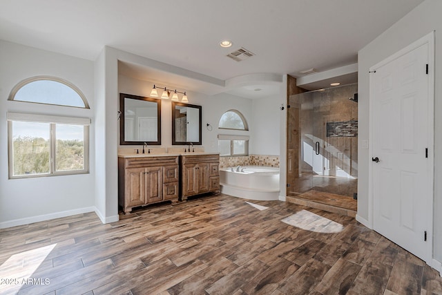 bathroom featuring vanity, independent shower and bath, and wood-type flooring