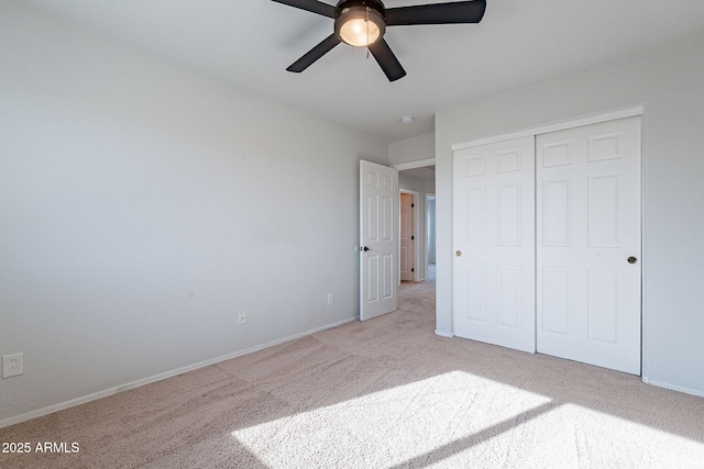 unfurnished bedroom with ceiling fan, light carpet, and a closet