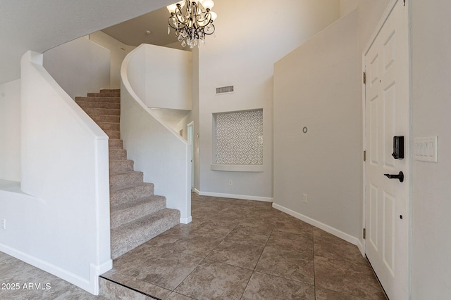 staircase with a notable chandelier and a high ceiling