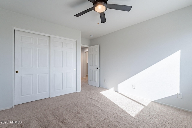 unfurnished bedroom with light carpet, a closet, and ceiling fan