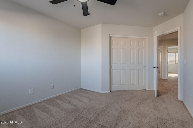 unfurnished bedroom featuring light carpet, a closet, and ceiling fan