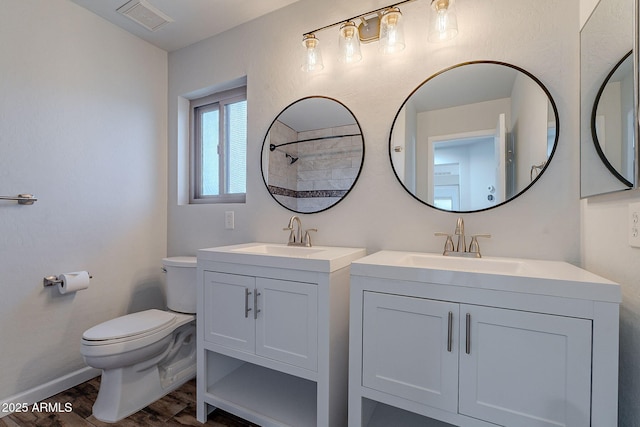 bathroom featuring wood-type flooring, vanity, and toilet