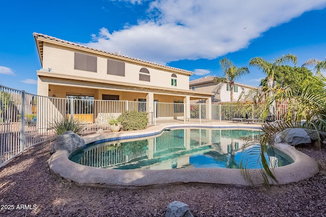 back of property featuring a fenced in pool