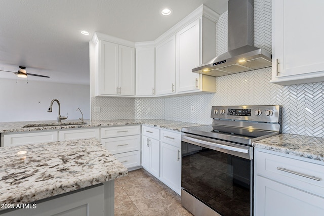 kitchen with white cabinets, decorative backsplash, electric stove, and wall chimney range hood