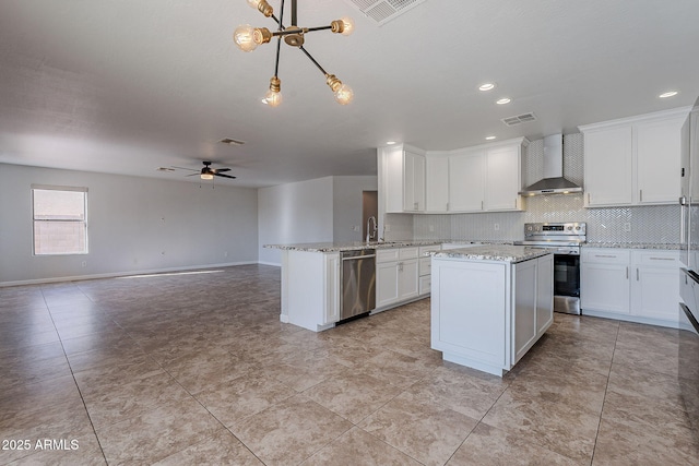 kitchen with white cabinetry, ceiling fan, wall chimney range hood, kitchen peninsula, and appliances with stainless steel finishes