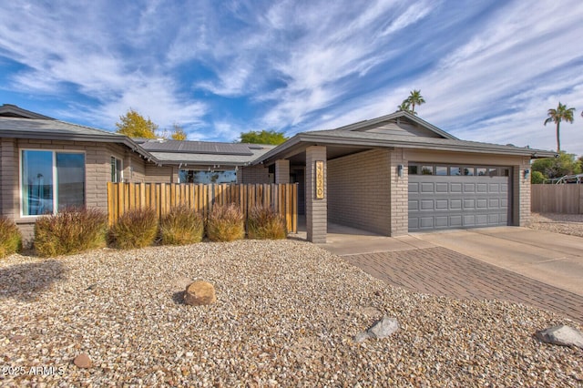 single story home featuring a garage and solar panels